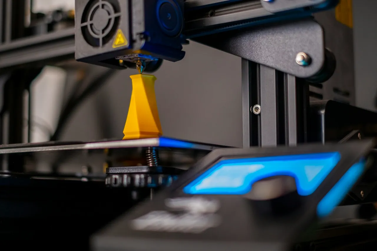 Mlaznica 3D printera nanosi žuti filament tijekom ispisa predmeta